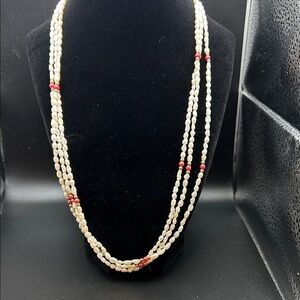Three strand white bead necklace with pink and gold color accents. 12”